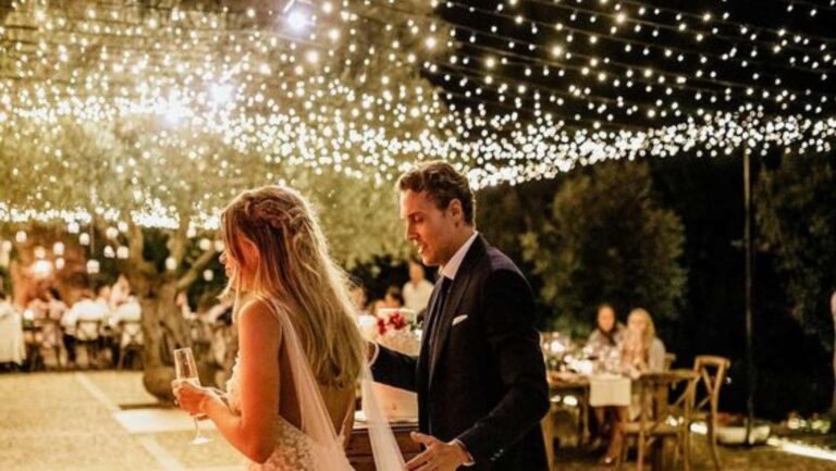 Bride and groom walking to the dance floor under a fairy light canopy